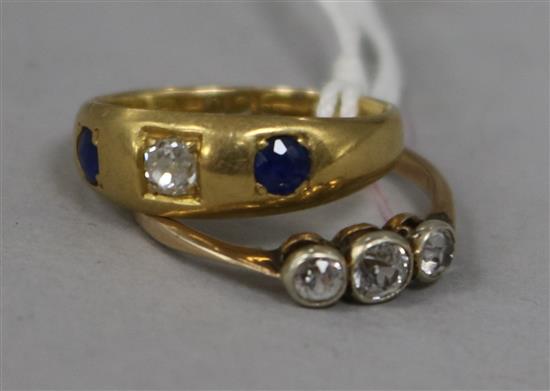 A three stone diamond ring and an 18ct gold sapphire and diamond ring.